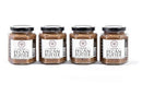 Four jars of Millican Pecan Creamy Pecan Butter - 8.5 oz Natural Texas Pecan Spread are lined up on a white background, each with a black lid and a white label with black text.