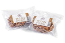 Two individually wrapped Millican Pecan Old-Fashioned Pecan Log Rolls (5 oz) in clear plastic packaging with white and brown “Pecan Log Roll” labels. Made by Millican Pecan, these rolls are coated in chopped Texas pecans for an authentic taste of classic Southern candy.