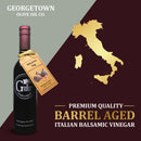 A bottle of Georgetown Olive Oil Co. Mission Fig Balsamic Vinegar sits beside a gold map of Modena, Italy on a red and cream background, with text emphasizing its Premium Quality Barrel Aged Italian Balsamic Vinegar.