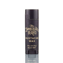 A black tube of The Immaculate Beard Immaculate Heavy Duty Beard Mustache Wax For Thick Facial Hair, 0.15 oz (4.25g), Batch 1991, stands upright on a reflective surface with a white background—perfect for precise beard styling with this premium beeswax mustache wax.