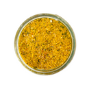 A clear glass jar of SALTOPIA Infused Sea Salts’ French Mustard Salt: MUSTARD BEEN LOVE, a coarse yellow seasoning with green and white flecks, seen from above on a white background.