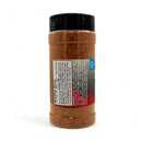 A plastic spice container with a black lid holds Myron Mixon Honey Money Cluck BBQ Seasoning. The side label lists nutritional facts and product details for this reddish-brown chicken seasoning from Myron Mixon.