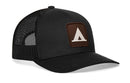 The Haka Hat Tent Trucker Hat is a black snapback by Haka Hat, featuring a mesh back, solid front, and a brown patch with a white geometric triangle inspired by campground trail signs.