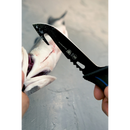 A person uses a Dalstrong Fishing Hook Knife 5" from the Night Shark Series, NSF Certified, with a serrated edge and gut hook to clean and fillet a fish on a gray surface.