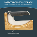 Store your mezzaluna knife with a black handle securely in the NULU Inc. NULU Knife Holder Dock, made from acacia wood and labeled “NULU,” which offers safe countertop storage and full blade coverage for optimal protection.