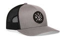 The Haka Hat New York City Trucker Hat | Gray-Black NYC X Snapback features a gray front, black mesh back, and a round patch with crossed lines and a New York state outline for classic comfort and style.