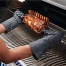 Napoleon grey leather BBQ gloves with long forearm protection and hanging loops. In use with Napoleon grill. 
