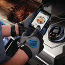 Person using a smartphone app on a grill with gloves, showing digital temperature display.