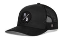 The Haka Hat North Dakota Trucker Hat in black features a mesh back, adjustable snapback, and a round front patch with "N" and "D" separated by a diagonal line. Brand: Haka Hat.