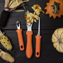 The Messermeister Pumpkin Carving Set - 3 Piece features orange-handled tools displayed on a black wooden surface with pumpkins, corn, seeds, and gourds—ideal for your next Halloween carving session.