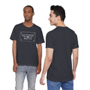 Two men wear the Printify Old Country BBQ Pits Vintage Logo T-Shirt with dark gray jeans; one faces forward showing the chest logo, while the other is turned away from the camera.