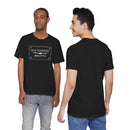 Two men model the Printify Old Country BBQ Pits Vintage Logo T-Shirt; one faces forward showing the white logo, while the other stands with his back to the camera. Both wear blue jeans, posing against a white background.
