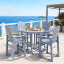 Overlooking the ocean with boats and islands, the DirectDeals Outdoor Bar Stool 29″ Height with Backrest and Armrests forms part of a gray patio set with five chairs and a round table holding drinks and snacks.