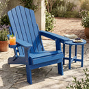 A blue DirectDeals Folding Adirondack Chair with Adjustable Backrest & Cup Holder sits on a stone patio with a matching side table, orange drink on the arm, surrounded by potted plants and sunlight.