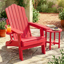 A vibrant red DirectDeals Folding Adirondack Chair with Adjustable Backrest & Cup Holder sits on a sunny patio, next to a table with dessert, blueberries, and a book among potted flowers.