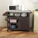 The DirectDeals Outdoor Grill Cart with Storage Cabinet Shelves and Stainless Steel Top-Brown holds a microwave, dishes, and kitchen items next to a counter with outlets on a light wall and wooden floor.