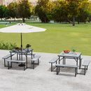 The DirectDeals 3-Piece Patio Bar Set Outdoor Grill Gazebo and 2 Folding Bar Stools sits on a patio with food, drinks, and a large white umbrella nearby, overlooking a grassy field with trees.