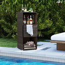 A DirectDeals Outdoor Storage Cabinet Patio Wicker Organizer with Drawer stands by the pool, holding liquor bottles, rolled towels, and a flower basket, set against a backdrop of lush green plants.