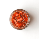 A jar of Taycte Famiglia Crispino Explosive Calabrian Hot Chili Peppers - Italian Peperoncini in Extra Virgin Olive Oil, viewed from above on a white background.