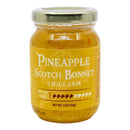 A jar of Powerful Pepper Pineapple Scotch Bonnett Chili Jam from the Powerful Pepper Company with a gold lid. The yellow label indicates a heat level of 5 out of 10 and a net weight of 4 oz (113g). This Caribbean-inspired jam combines the bold flavors of Freeport Orange Scotch Bonnet peppers and sweet pineapple for a uniquely tropical kick.