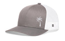 The Haka Hat Palm Tree Trucker Hat features a gray and white design, curved bill, mesh back, and an embroidered palm tree on the front left panel. Brand: Haka Hat. Style: Island Snapback.