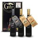 Three bottles from Georgetown Olive Oil Co.'s Pasta Trio - Olive Oil Gift Collection—featuring Black Truffle, Pesto Infused, and Porcini Mushroom Extra Virgin Olive Oils—are elegantly arranged in front of a decorative gift box labeled "Pasta Trio Collection" by Georgetown Olive Oil Co.