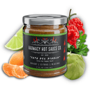 A jar of Harmacy Hot Sauce Co. Pata del Diablo Extra Hot Tomatillo & Clementine Sauce 9oz stands before a sliced lime, tangerine, green apple, and super-hot peppers. The label showcases vibrant citrus flavors.