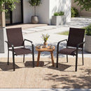Two brown Patio Dining Chairs Set of 2/4/6 Stackable Outdoor Armchairs by DirectDeals sit beside a small wooden table with cups, a teapot, and flowers on a woven rug in a stylish patio with potted plants.