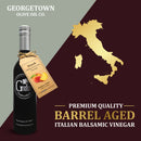 A bottle of Georgetown Olive Oil Co. Peach White Balsamic featuring a tag, displayed beside a gold map of Italy. Text reads: Premium quality, barrel-aged white balsamic vinegar from Modena, Italy by Georgetown Olive Oil Co.
