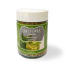 A 6oz jar of SALTOPIA Infused Sea Salts labeled Saltopia Basil, Garlic & Lemon Salt: PRESTO PESTO features a green label with pesto and basil images, a white lid, and an herb blend of basil, garlic, lemon, and sea salt.