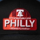 A close-up of the Haka Hat Philly City of Brotherly Love Trucker Hat, a black cityscape snapback featuring a red and white patch with "City of Brotherly Love PHILLY Pennsylvania" and an image of the Liberty Bell.