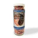 A clear jar with a blue label holds SALTOPIA Infused Sea Salts: Pink Himalayan & Gourmet Peppercorn Grinder Set—an ideal addition to any grinder set.
