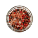 A top-down view of the SALTOPIA Infused Sea Salts Saltopia Pink Himalayan & Gourmet Peppercorn Grinder Set, filled with pink Himalayan salt, black peppercorns, and red peppercorns, set against a white background.