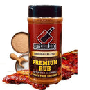 A container of Butcher BBQ Premium Barbecue Rub by Butcher BBQ is pictured in front of cooked ribs, with a wooden bowl and scoop of seasoning in the background. The label reads Trust Your Butcher.