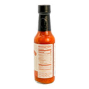 A glass bottle of Powerful Pepper Smoked Mango Habanero Hot Sauce from Powerful Pepper Company with a black cap, featuring nutrition facts and an ingredient list on the label. Made with Caribbean red habaneros and sweet Georgia Vidalia onions, the orange-red sauce inside adds bold flavor to your dishes.