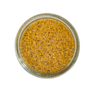 A glass jar of Saltopia Lemon Pepper Salt: PUCKER UP BUSTER by SALTOPIA Infused Sea Salts, filled with coarse yellow and brown citrus seasoning, viewed from above against a white background.