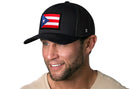 Man wearing a Haka Hat Puerto Rico Flag Trucker Hat, a black PR snapback featuring a vibrant flag patch.