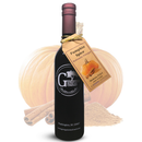A dark glass bottle of Georgetown Olive Oil Co. Pumpkin Spice Balsamic Vinegar, adorned with a tag, is displayed in front of a pumpkin, cinnamon sticks, and ground spices. The label features the Georgetown Olive Oil Co. brand and emphasizes the rich flavor of aged balsamic vinegar crafted in Modena, Italy.