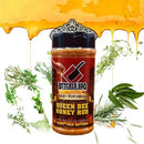 A jar of Butcher BBQ Queen Bee BBQ Seasoning Rub by Butcher BBQ sits centered with honey dripping above and fresh rosemary and parsley nearby. The red label shows a cutting board logo and a honey dipper.