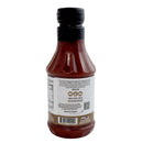A plastic bottle of Hickman's BBQ Appalachian Red Gluten Free Vinegar-Based BBQ Sauce (18 oz, pack of 2) is shown from the back, featuring a black cap and a white label with text, a barcode, nutritional facts, and a heat level indicator for mild spiciness. This vinegar-based sauce from Hickman's BBQ is clearly labeled as gluten free.
