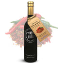 A dark bottle of Georgetown Olive Oil Co. ROASTED CHILI & SPICE Infused High Polyphenols Extra Virgin Olive Oil, featuring a tag labeled “Roasted Chili & Spice.” Red and green chili peppers and dried spices in the background emphasize this bold, cold-pressed olive oil’s spicy character from Georgetown Olive Oil Co.