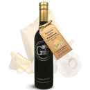 A dark bottle of Georgetown Olive Oil Co. Roasted Garlic Parmesan Infused High Polyphenols Extra Virgin Olive Oil with a tag, placed in front of garlic bulbs and parmesan cheese pieces. This premium olive oil from Georgetown Olive Oil Co. is crafted to deliver rich roasted garlic and parmesan flavors, making it perfect for elevating any dish.