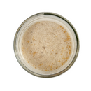 A clear glass jar of SALTOPIA Vanilla Bean & Salted Caramel Sugar: ROOM FOR DESSERT by SALTOPIA Infused Sea Salts, filled with coarse light brown and white sugar, viewed from above on a white background.