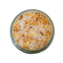 A glass jar of SALTOPIA Infused Sea Salts' Saltopia Garlic & Onion Salt: ROOT MATES, filled with coarse sea salt, dried minced garlic, and herbs, is viewed from above on a white background.