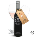 A bottle of Georgetown Olive Oil Co. Rosé White Balsamic Vinegar from Georgetown Olive Oil Co., featuring a brown tag and crafted in the style of fine Modena balsamic, is positioned in front of two glasses filled with a light pink liquid. A No Alcohol symbol appears in the bottom right corner.