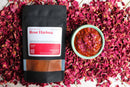 A packet of World Spice Rose Harissa and a small bowl of this richly textured red harissa paste rest on a bed of dried rose petals. Created by World Spice, this blend is garnished with rose petals and delivers vibrant citrus and floral notes in each spoonful, inspired by Ottolenghi’s flavors.