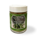 A jar of SALTOPIA Infused Sea Salts Rosemary Salt: SCARBOROUGH FAIR, with a white lid and green label featuring rosemary—an herb-infused salt ideal for savory dishes.