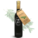 A dark bottle of Georgetown Olive Oil Co. Rosemary Infused | High Polyphenols Extra Virgin Olive Oil with a tan tag, set against a backdrop of rosemary sprigs. This cold pressed olive oil from Georgetown Olive Oil Co. captures the fresh flavor of rosemary and offers high polyphenol content for outstanding taste and health benefits.