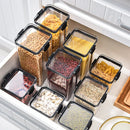 Nine clear, square Lovely Home Icon 1-4PCS Sealed Jars Kitchen Organizer Grain Storage Boxes are filled with an assortment of dried beans, pasta, and grains and are neatly arranged in a white kitchen drawer.