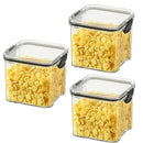 Three Lovely Home Icon 1-4PCS Sealed Jars Kitchen Organizer Grain Storage Boxes with black locking lids, each filled with yellow cornflakes, are arranged in a triangle on a white background.